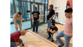 Lenny Hall walking students through hardwood installation